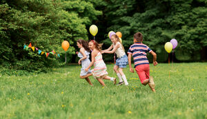 happy kids playing tag game at birthday party