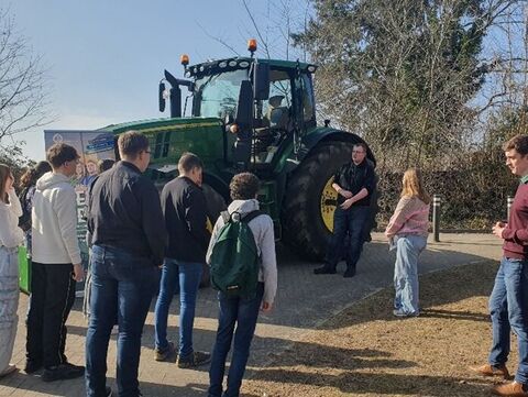 Auszubildende vor einem Traktor