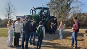 Auszubildende vor einem Traktor